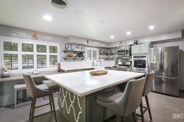 6513 Desmond Ct, Bakersfield, CA 93308 - kitchen featuring appliances with stainless steel finishes, open shelves, finished concrete floors, light countertops, and a breakfast bar