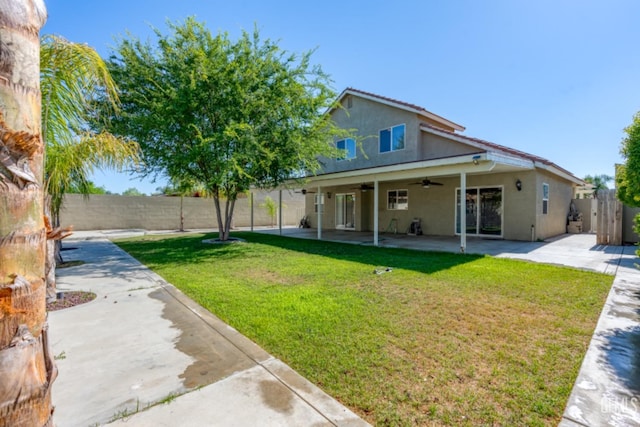 back of house with a yard, a patio, and ceiling fan