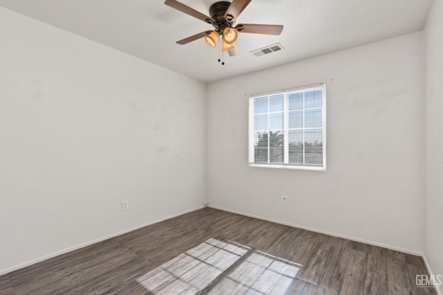 empty room with ceiling fan and dark hardwood / wood-style flooring