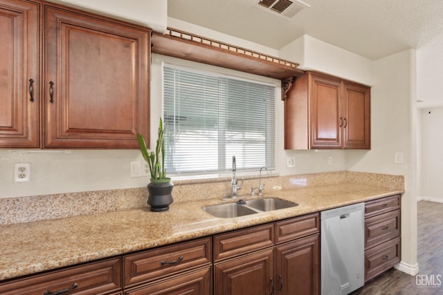 kitchen featuring dark hardwood / wood-style flooring, light stone counters, sink, and stainless steel dishwasher