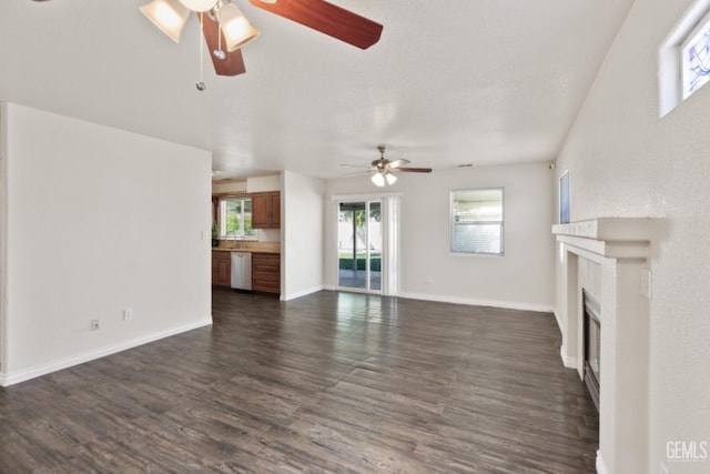 unfurnished living room featuring ceiling fan and dark hardwood / wood-style floors