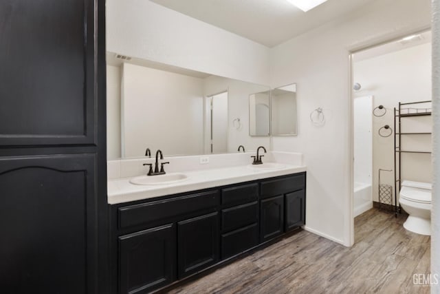 full bathroom featuring toilet, shower / washtub combination, vanity, and hardwood / wood-style flooring