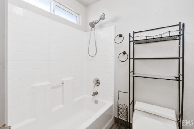 bathroom featuring shower / bathing tub combination and toilet