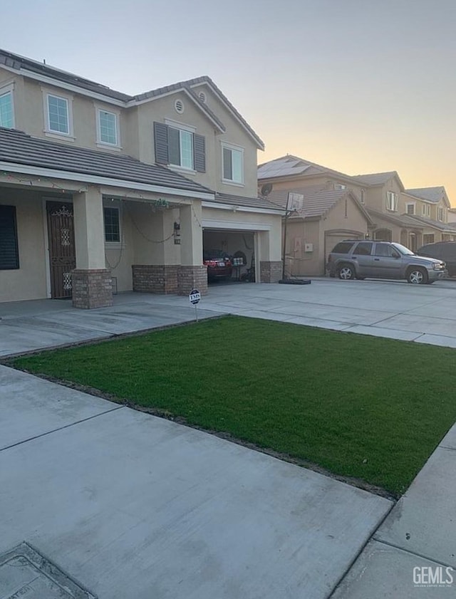5017 Clear Crystal Dr, Bakersfield, CA 93313 - view of front of house with a yard, concrete driveway, an attached garage, and stucco siding