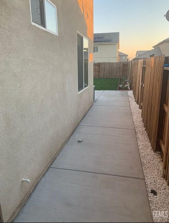 5017 Clear Crystal Dr, Bakersfield, CA 93313 - property exterior at dusk with stucco siding, a fenced backyard, and a patio