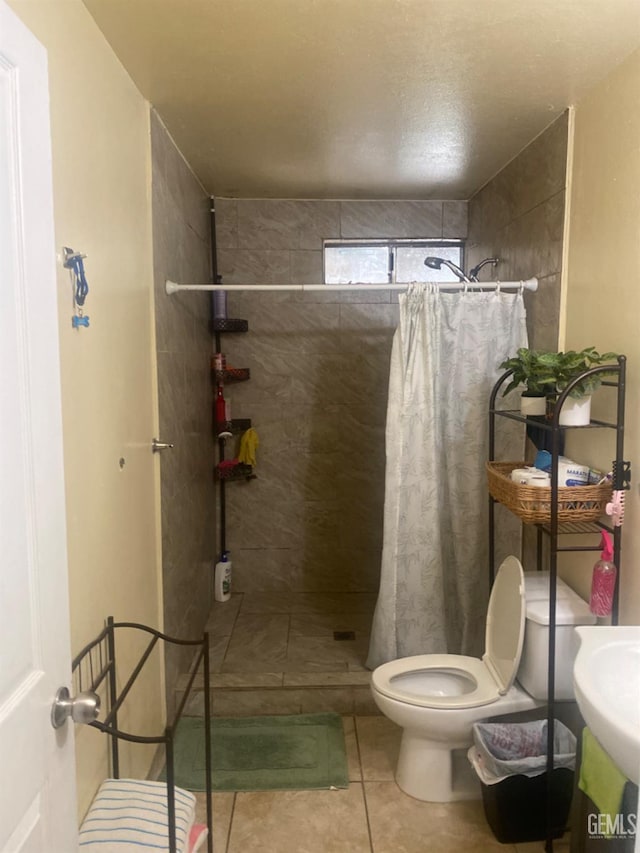 full bath featuring tiled shower, tile patterned flooring, and toilet