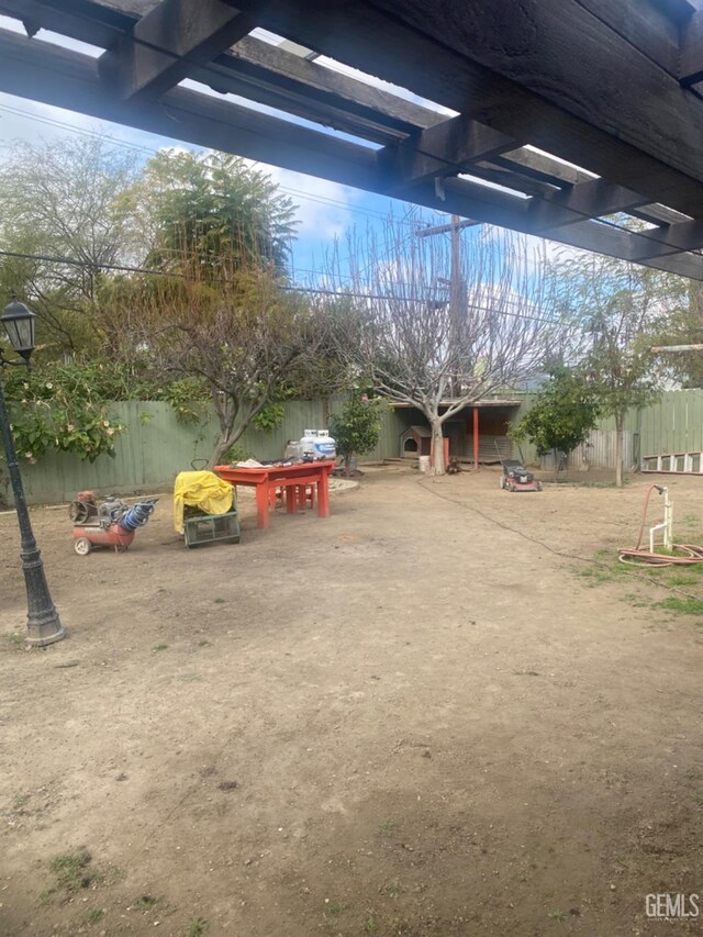 view of yard with fence and a pergola