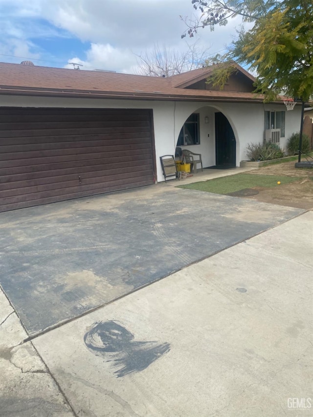 view of front of home featuring an attached garage, driveway, and stucco siding