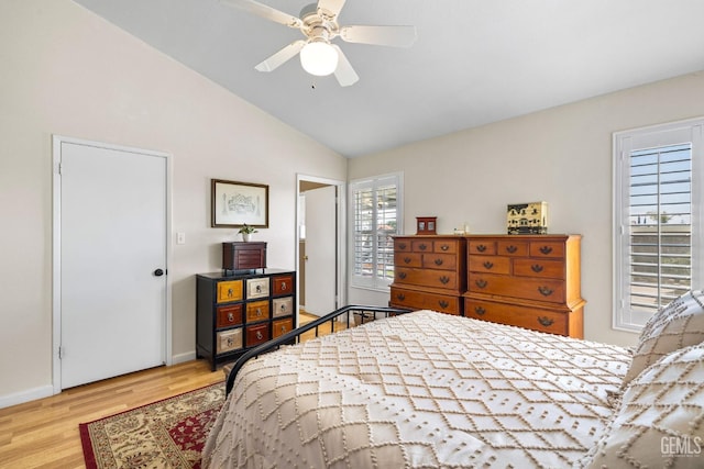 bedroom with a ceiling fan, baseboards, lofted ceiling, and wood finished floors