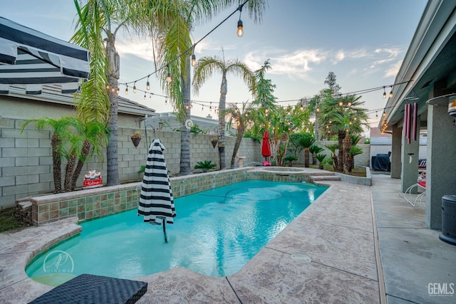 view of pool featuring a patio area, a pool with connected hot tub, and a fenced backyard