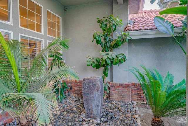 exterior space with a tile roof and stucco siding