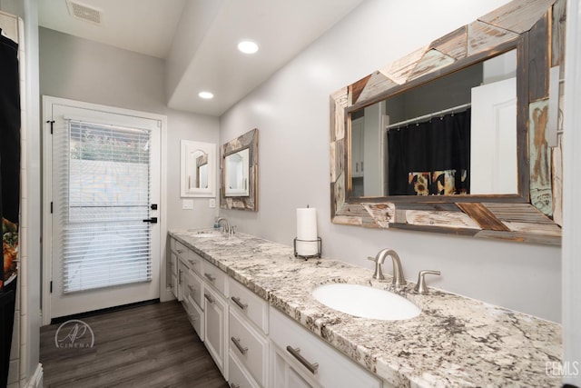 full bath featuring recessed lighting, wood finished floors, a sink, visible vents, and double vanity