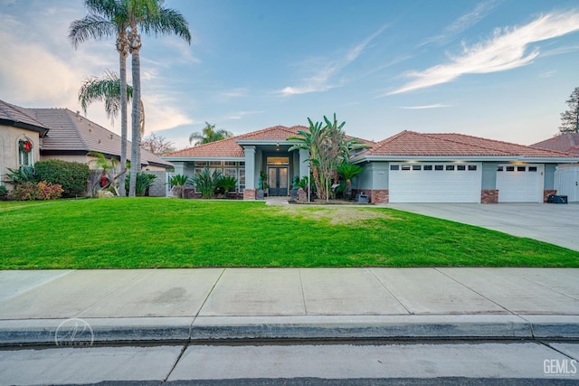 mediterranean / spanish house with driveway, stucco siding, a garage, and a front yard