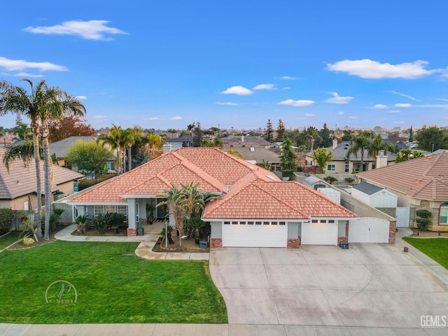 mediterranean / spanish house featuring a tile roof, concrete driveway, an attached garage, a front yard, and a residential view