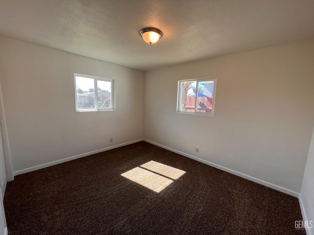 carpeted spare room featuring a textured ceiling