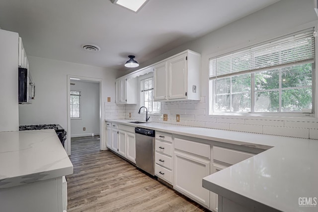 201 Cedar St, Bakersfield, CA 93304 - kitchen with stainless steel dishwasher, a sink, white cabinetry, and decorative backsplash