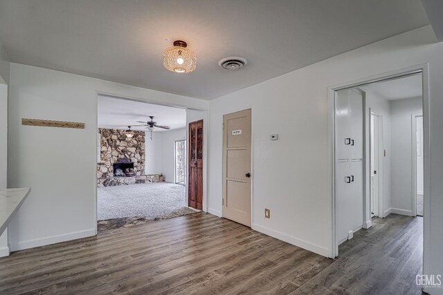 201 Cedar St, Bakersfield, CA 93304 - unfurnished dining area with a stone fireplace, wood finished floors, baseboards, and ceiling fan