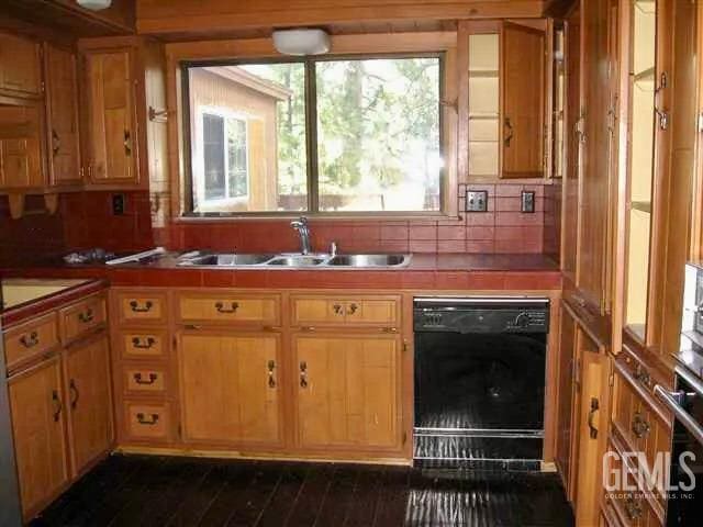 kitchen featuring black dishwasher, tile countertops, and sink