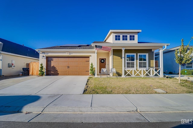 view of front of home with covered porch, a garage, concrete driveway, roof mounted solar panels, and stucco siding