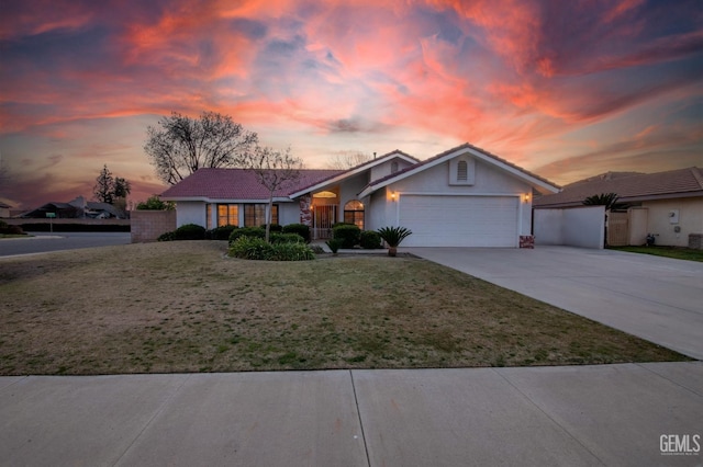 ranch-style house with a yard, driveway, an attached garage, and stucco siding