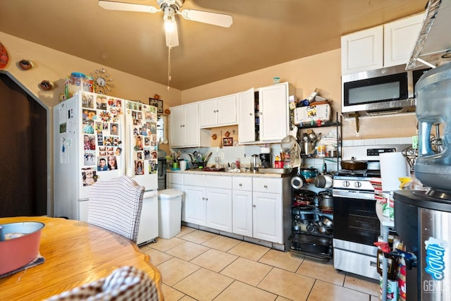 kitchen featuring ceiling fan, light tile patterned floors, white cabinets, and stainless steel appliances