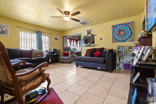 tiled living room with ceiling fan and a textured ceiling