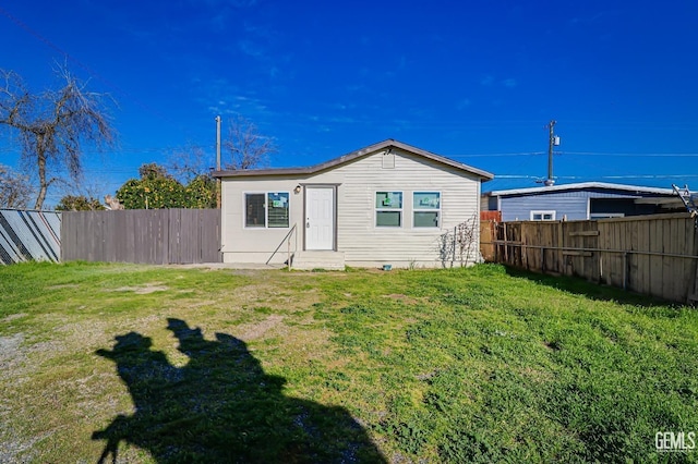 rear view of property with a lawn