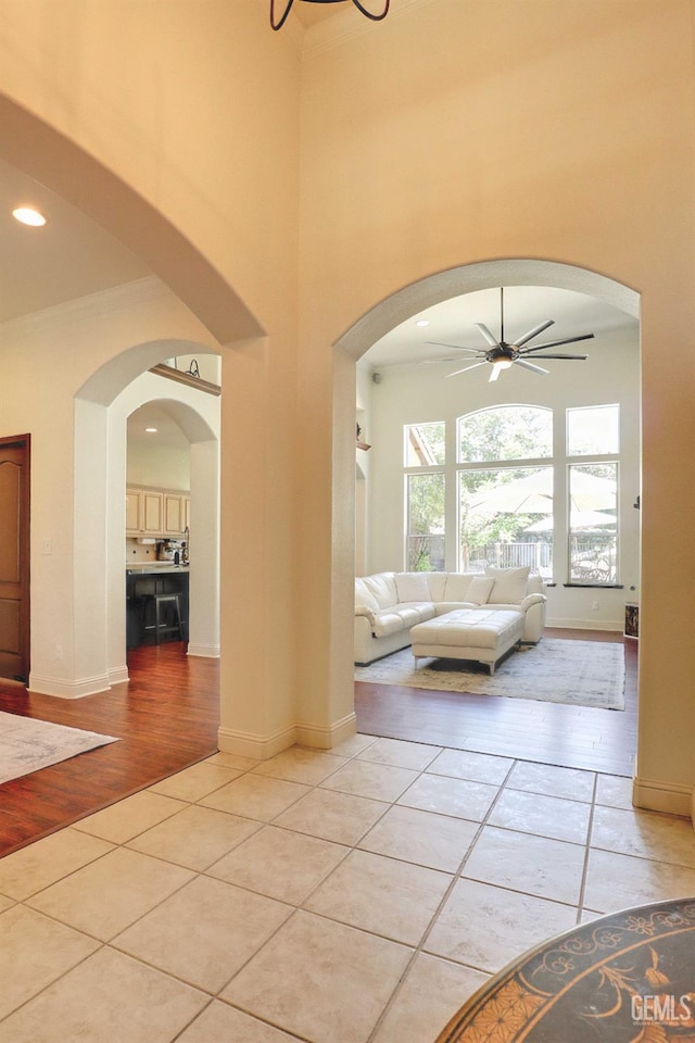 1881 Richert Ave, Clovis, CA 93611 - entryway with light tile patterned flooring, a ceiling fan, arched walkways, a towering ceiling, and ornamental molding