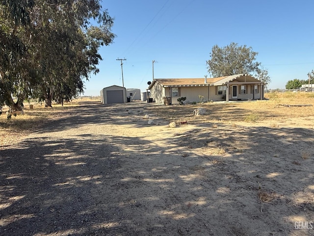 33391 7th Standard Rd, Bakersfield, CA 93314 - view of front of house featuring a detached garage, an outbuilding, and dirt driveway