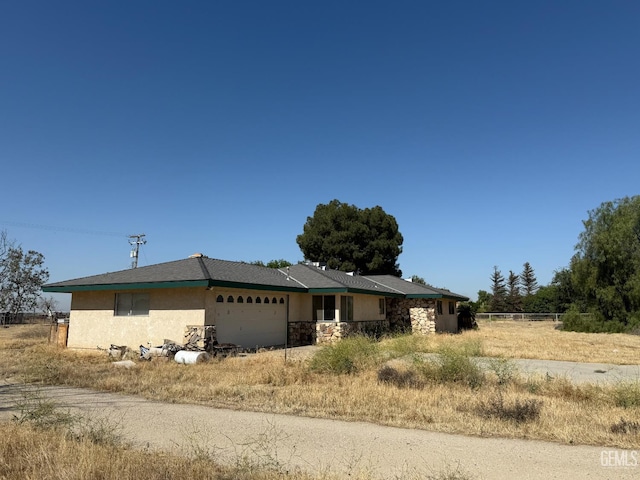 33391 7th Standard Rd, Bakersfield, CA 93314 - view of front of house with an attached garage, stucco siding, and stone siding