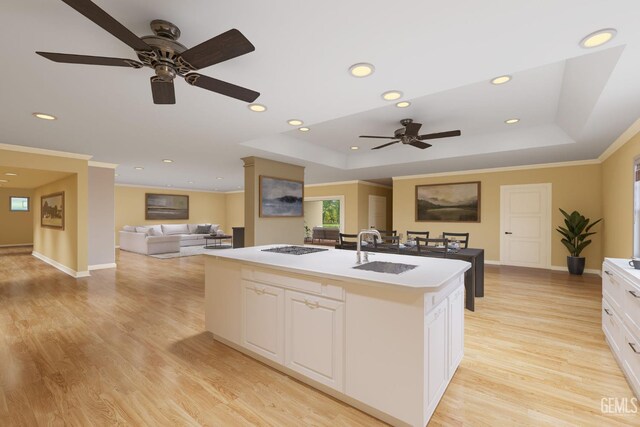 1191 Edmund St, Bakersfield, CA 93309 - kitchen with ceiling fan, a kitchen island with sink, open floor plan, light wood-type flooring, and a tray ceiling