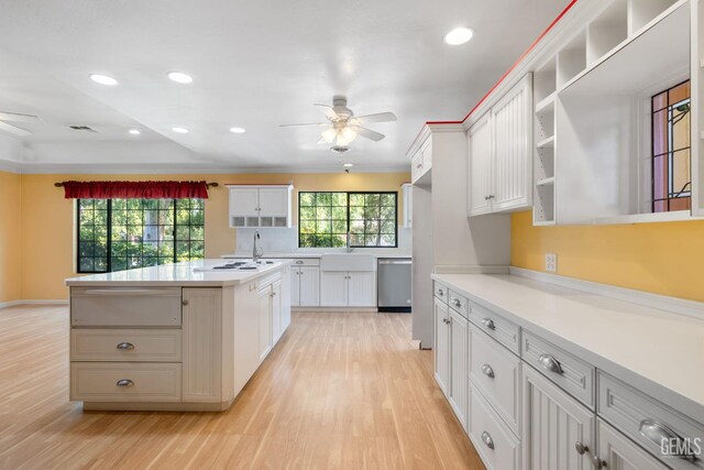1191 Edmund St, Bakersfield, CA 93309 - kitchen with ceiling fan, a warming drawer, stainless steel dishwasher, open shelves, and light wood-style flooring