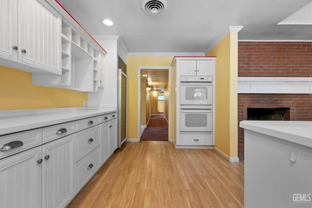 1191 Edmund St, Bakersfield, CA 93309 - kitchen with double oven, ornamental molding, open shelves, light wood finished floors, and light countertops