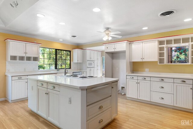 1191 Edmund St, Bakersfield, CA 93309 - kitchen featuring a warming drawer, open shelves, a ceiling fan, light wood finished floors, and a center island