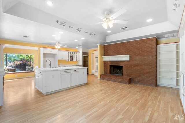 1191 Edmund St, Bakersfield, CA 93309 - kitchen featuring ceiling fan, open floor plan, light wood-style floors, white cabinets, and light countertops