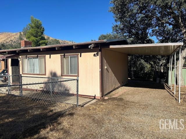 view of side of home with a mountain view and a carport