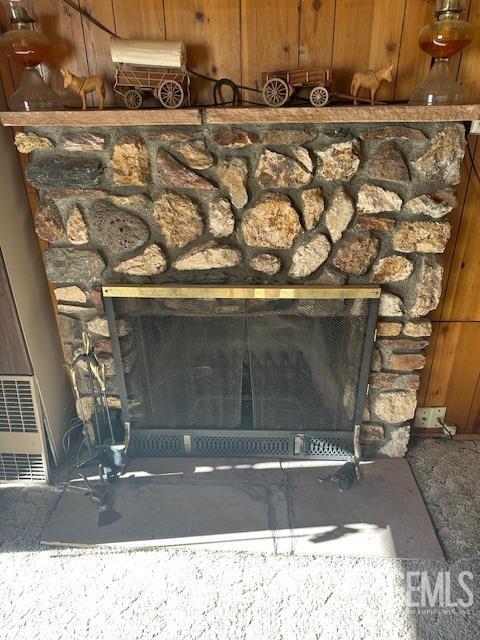 details featuring a stone fireplace and wood walls