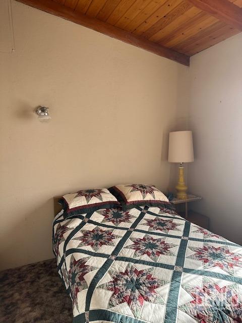 bedroom with carpet flooring and wood ceiling