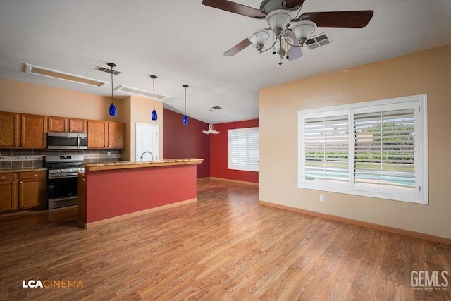 5605 Meadow Valley Ct, Bakersfield, CA 93312 - kitchen featuring appliances with stainless steel finishes, brown cabinets, lofted ceiling, wood finished floors, and a ceiling fan