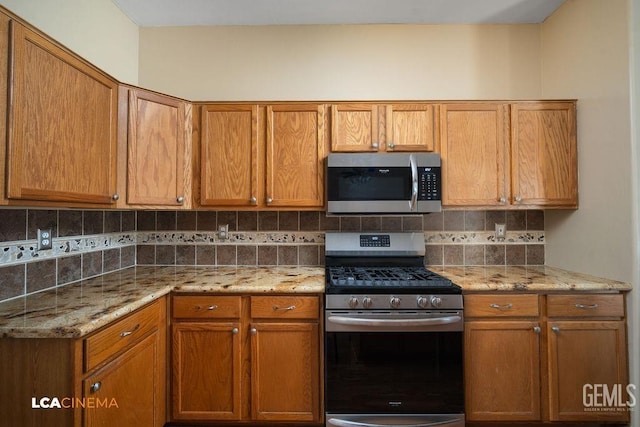 5605 Meadow Valley Ct, Bakersfield, CA 93312 - kitchen featuring stainless steel appliances, decorative backsplash, light stone counters, and brown cabinetry