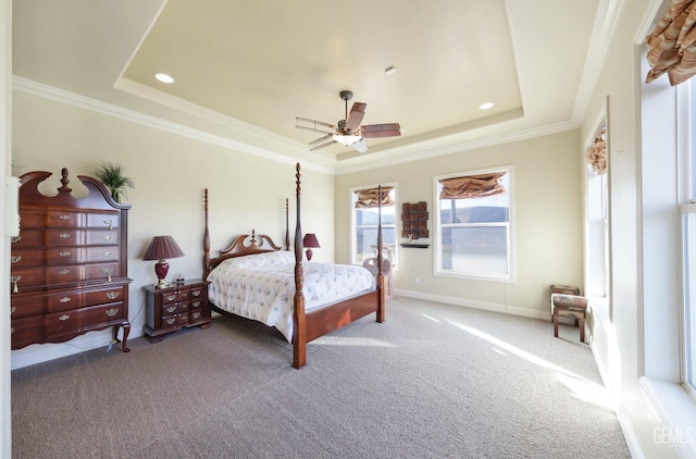 carpeted bedroom with ceiling fan, a tray ceiling, and crown molding