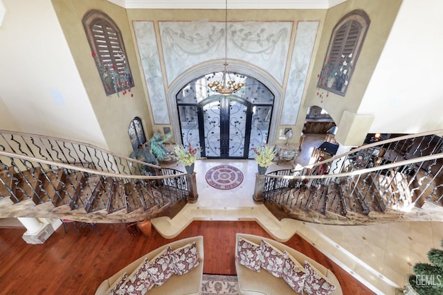 foyer with hardwood / wood-style flooring, french doors, and a chandelier