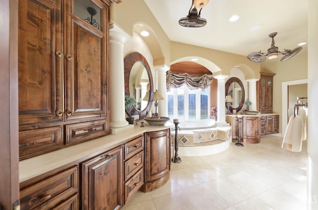 bathroom featuring ceiling fan, vanity, tile patterned flooring, a relaxing tiled tub, and ornate columns