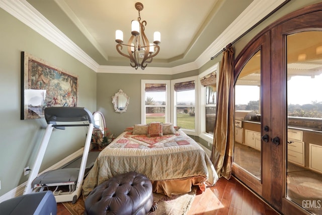 bedroom with a raised ceiling, dark wood-type flooring, crown molding, and a chandelier