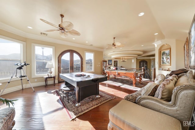 playroom featuring ceiling fan with notable chandelier, dark wood-type flooring, crown molding, and french doors