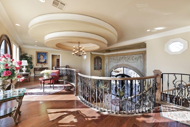 hallway featuring a notable chandelier, plenty of natural light, and crown molding