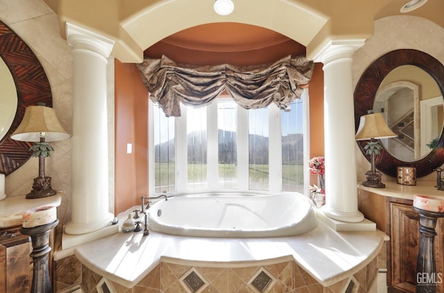 bathroom with tiled bath and ornate columns