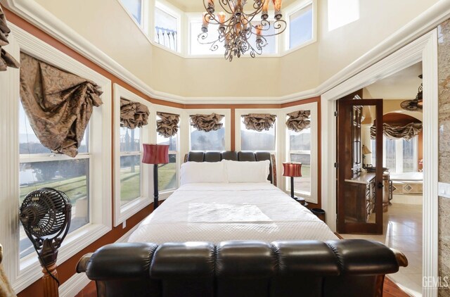 bedroom with multiple windows, a towering ceiling, and an inviting chandelier