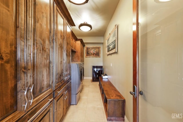 laundry room with cabinets, light tile patterned floors, and washing machine and clothes dryer