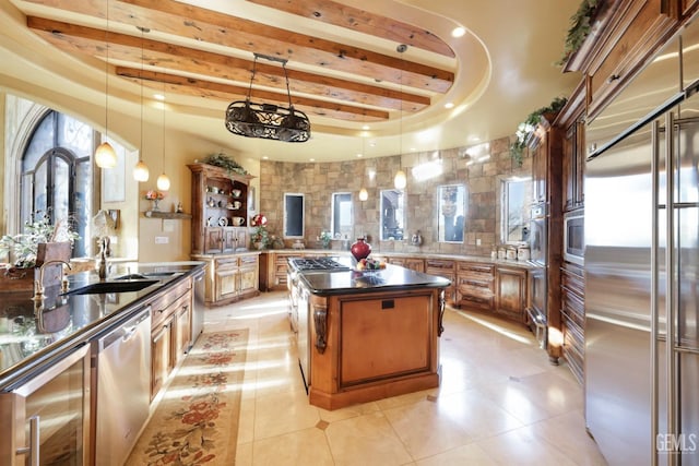 kitchen featuring kitchen peninsula, stainless steel appliances, a kitchen island, pendant lighting, and beam ceiling